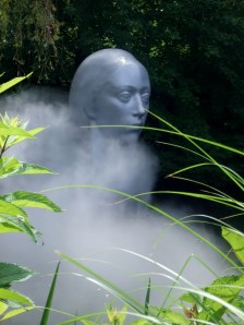 A giant ethereal woman floats out over the water.